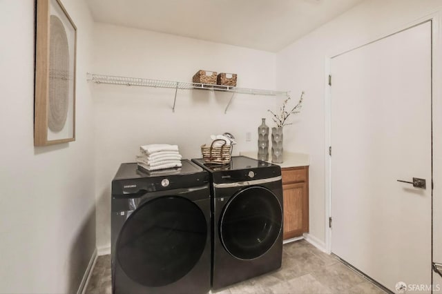 washroom featuring cabinets and washing machine and dryer