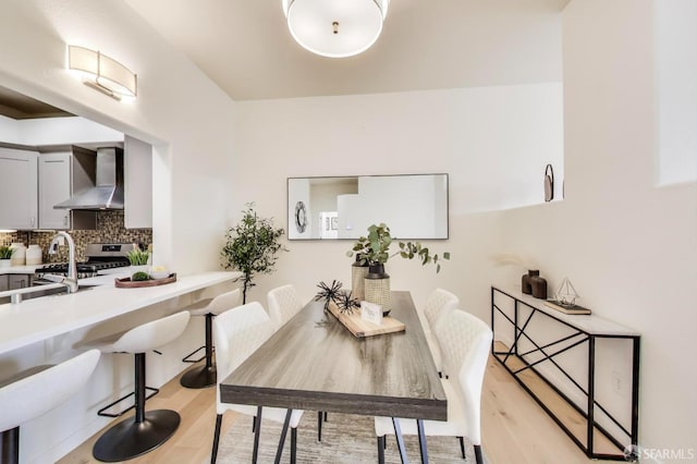 dining space featuring sink and light hardwood / wood-style flooring