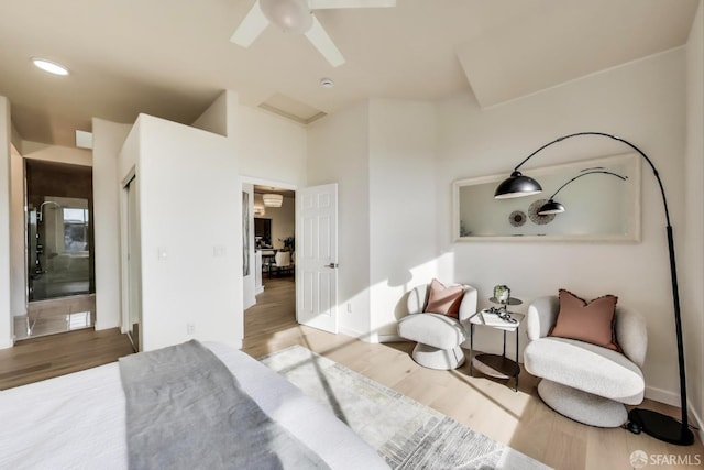 bedroom with hardwood / wood-style floors, ceiling fan, and ensuite bath