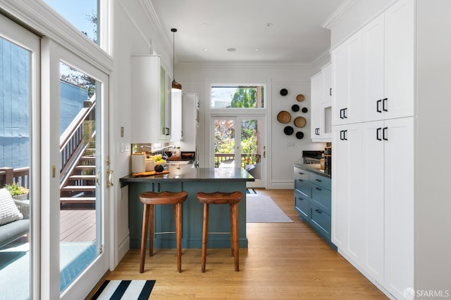 49 Hill St, San Francisco, CA 94110 - kitchen featuring dark countertops, light wood finished floors, white cabinetry, and crown molding