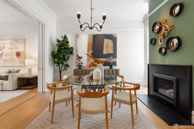 49 Hill St, San Francisco, CA 94110 - dining room with wood finished floors, a chandelier, crown molding, and a glass covered fireplace