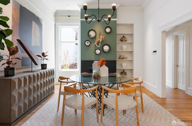 49 Hill St, San Francisco, CA 94110 - dining space featuring light wood-style flooring, built in shelves, ornamental molding, and a chandelier