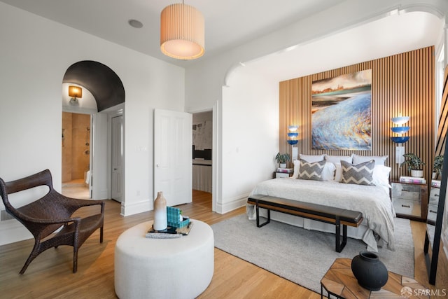 49 Hill St, San Francisco, CA 94110 - bedroom with arched walkways, light wood-style floors, and ensuite bathroom