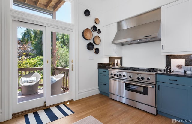 49 Hill St, San Francisco, CA 94110 - kitchen with high end range, wall chimney range hood, blue cabinets, and dark countertops