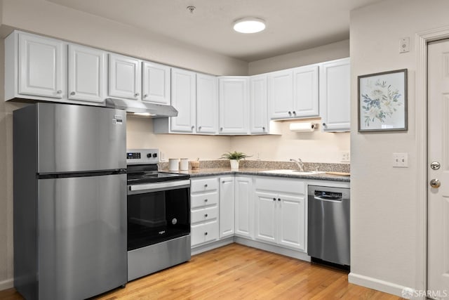 kitchen featuring appliances with stainless steel finishes, sink, light hardwood / wood-style flooring, and white cabinets