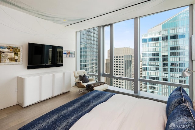 bedroom with wood-type flooring and expansive windows