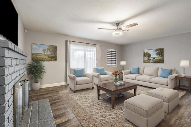 living room featuring a fireplace, dark hardwood / wood-style flooring, and ceiling fan