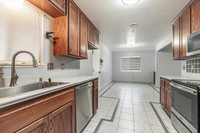 kitchen featuring sink, light tile patterned floors, and stainless steel appliances