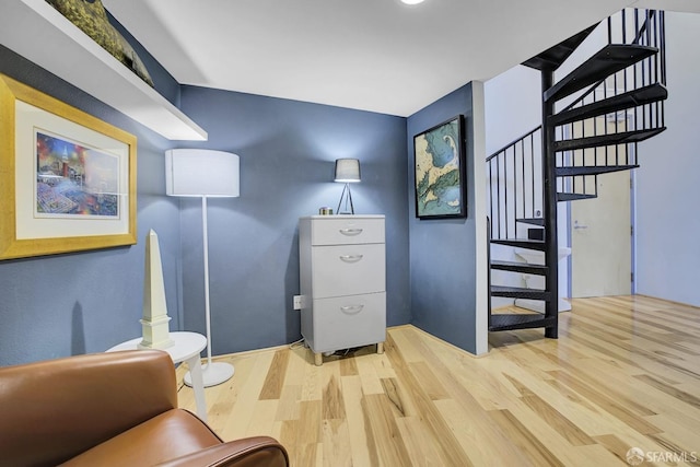 living area featuring stairway and wood finished floors