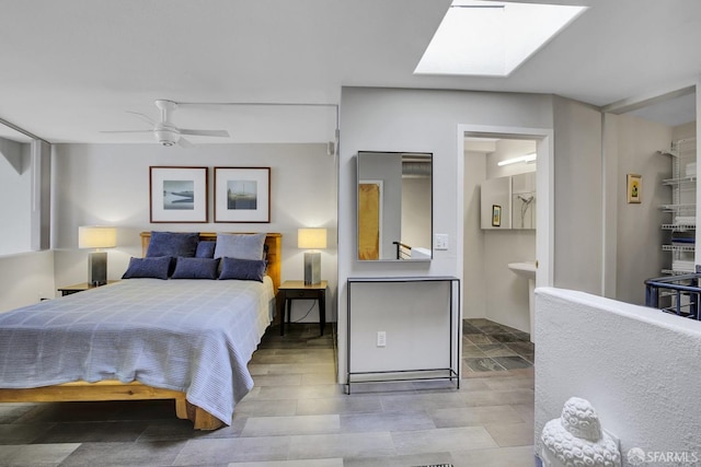 bedroom featuring a skylight, connected bathroom, and a ceiling fan