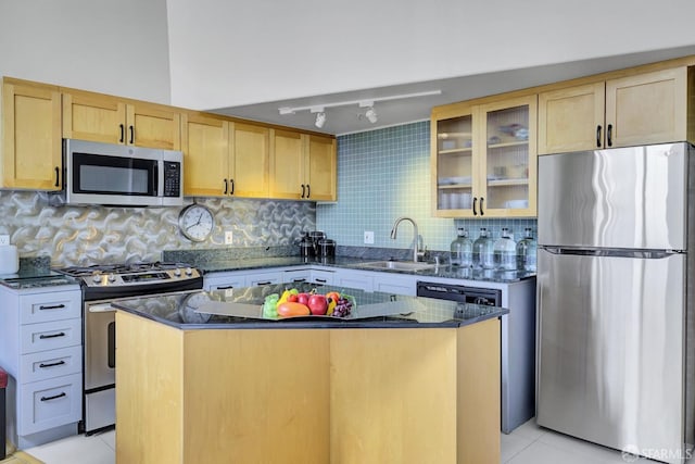 kitchen with glass insert cabinets, dark stone countertops, stainless steel appliances, a sink, and light tile patterned flooring