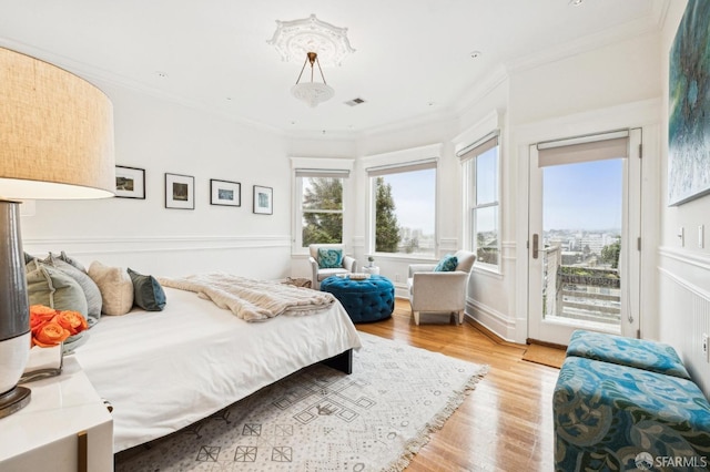 bedroom with access to exterior, ornamental molding, and light hardwood / wood-style floors