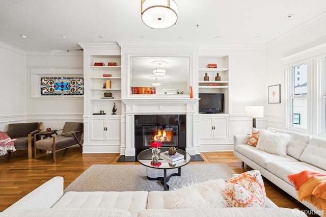 living room featuring crown molding, built in shelves, and hardwood / wood-style flooring