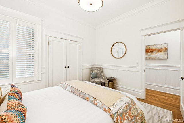 bedroom featuring crown molding, a closet, and hardwood / wood-style flooring