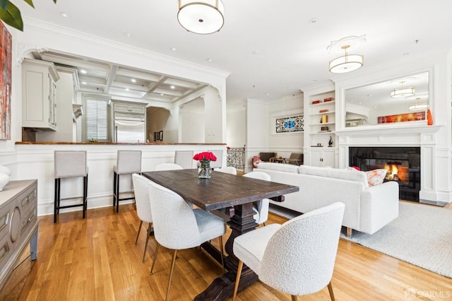 dining area featuring ornamental molding, coffered ceiling, beam ceiling, and light hardwood / wood-style flooring