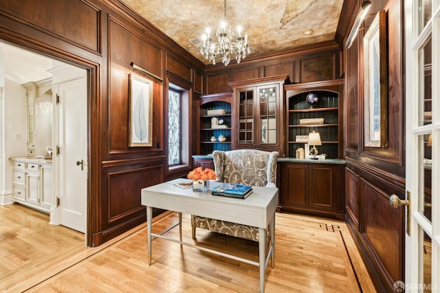 sitting room featuring a notable chandelier, ornamental molding, and light wood-type flooring