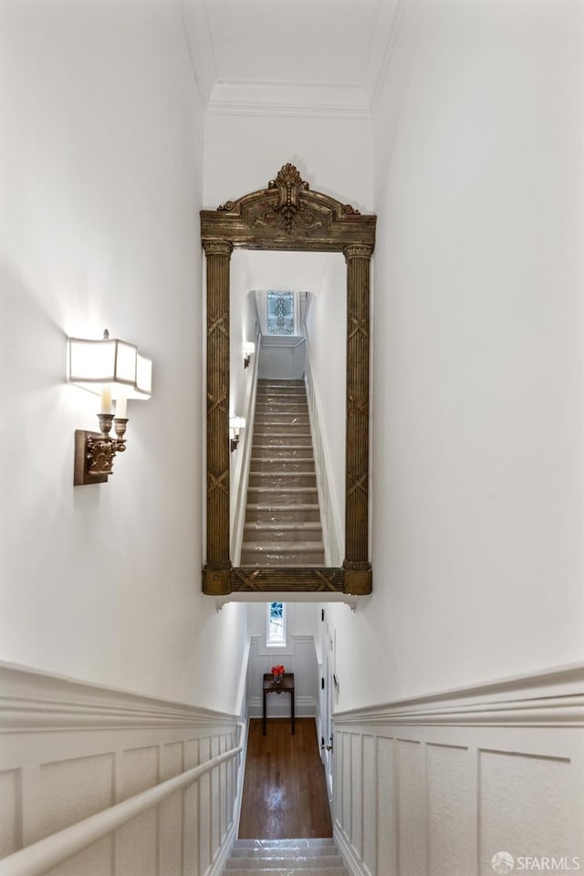 staircase with hardwood / wood-style flooring and ornamental molding