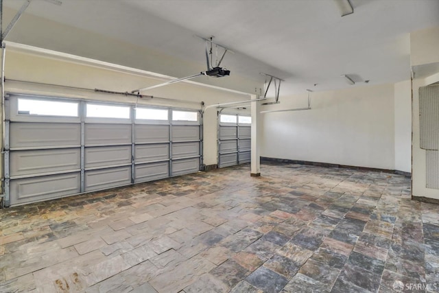 garage featuring a garage door opener and baseboards