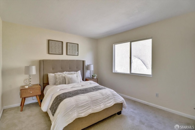 bedroom with baseboards and light colored carpet