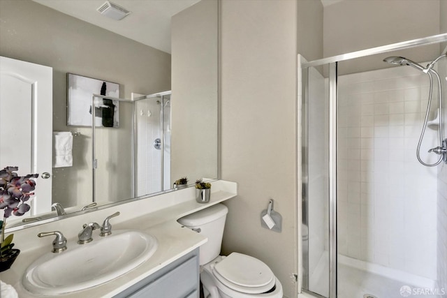 bathroom with toilet, vanity, a shower stall, and visible vents