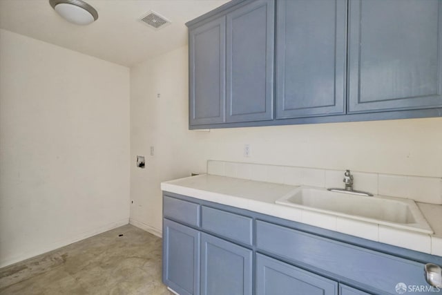 washroom with cabinet space, baseboards, visible vents, and a sink