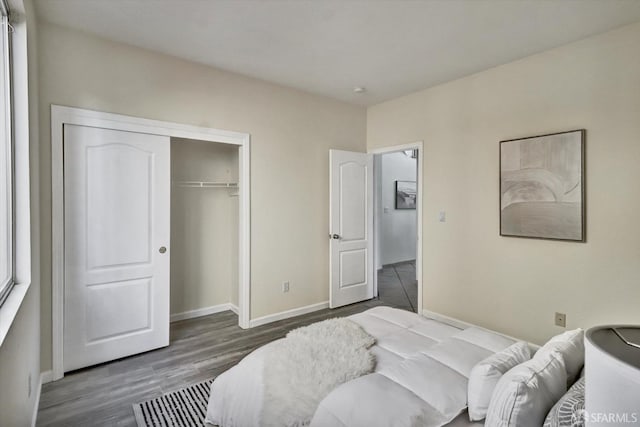 bedroom with a closet, baseboards, and wood finished floors