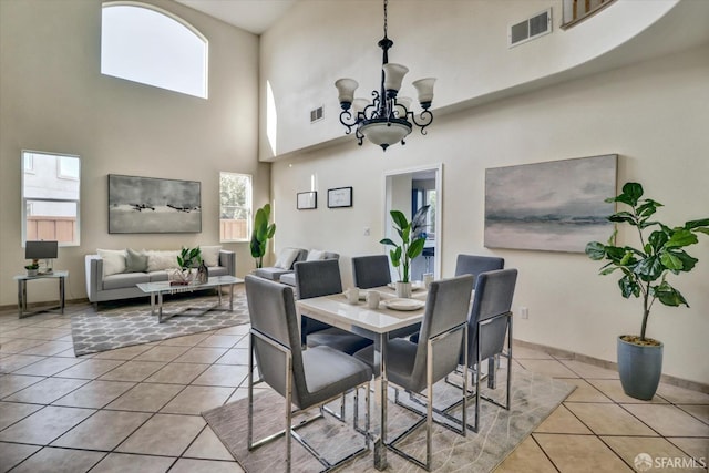 dining area featuring light tile patterned floors, visible vents, and a chandelier