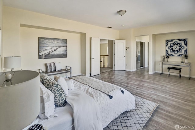 bedroom with baseboards and wood finished floors