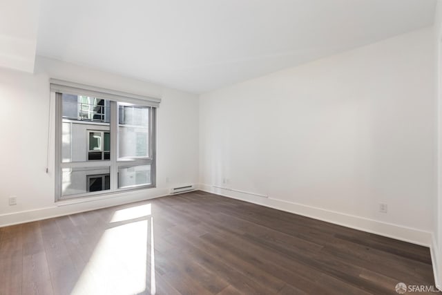 unfurnished room featuring dark wood-style floors, visible vents, and baseboards