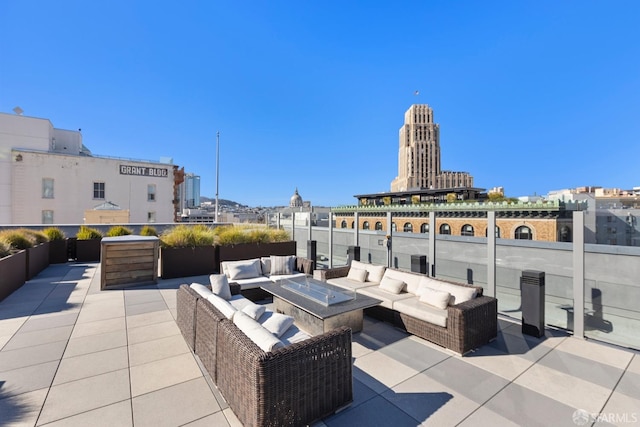 view of patio / terrace with an outdoor living space with a fire pit and a city view