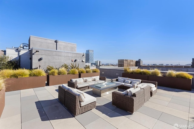 view of patio / terrace featuring a view of city and an outdoor living space with a fire pit