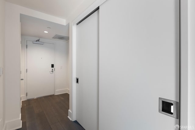 corridor featuring dark wood-type flooring and recessed lighting