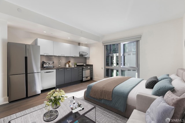 bedroom featuring recessed lighting, a sink, baseboards, light wood-style floors, and freestanding refrigerator