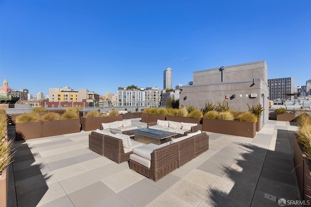 view of patio featuring an outdoor living space with a fire pit and a city view