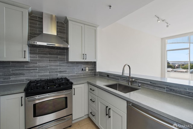 1600 Webster St Unit 409, San Francisco, CA 94115 - kitchen with a sink, track lighting, wall chimney exhaust hood, backsplash, and appliances with stainless steel finishes