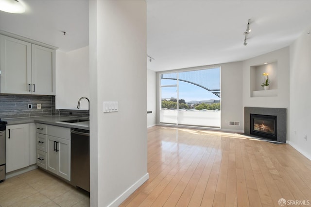 1600 Webster St Unit 409, San Francisco, CA 94115 - kitchen with a sink, open floor plan, rail lighting, stainless steel dishwasher, and visible vents