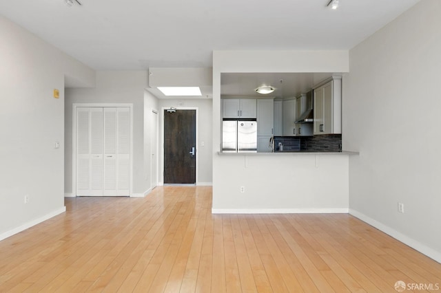 1600 Webster St Unit 409, San Francisco, CA 94115 - unfurnished living room featuring light wood-type flooring, baseboards, and a sink