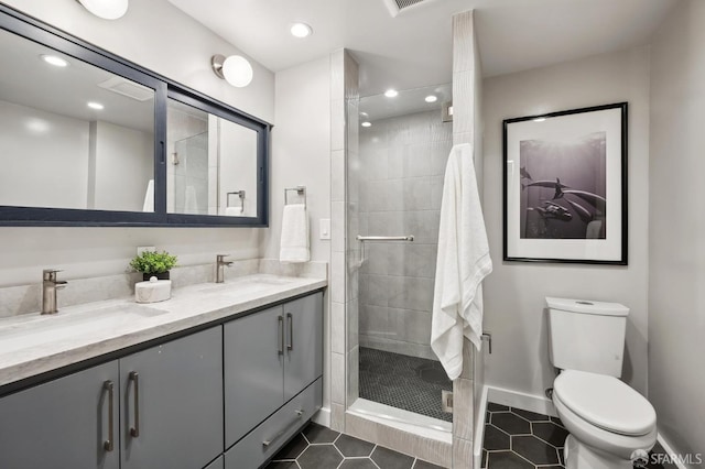 bathroom with tile patterned flooring, vanity, toilet, and a shower with door