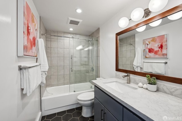 full bathroom with tile patterned flooring, vanity, toilet, and bath / shower combo with glass door