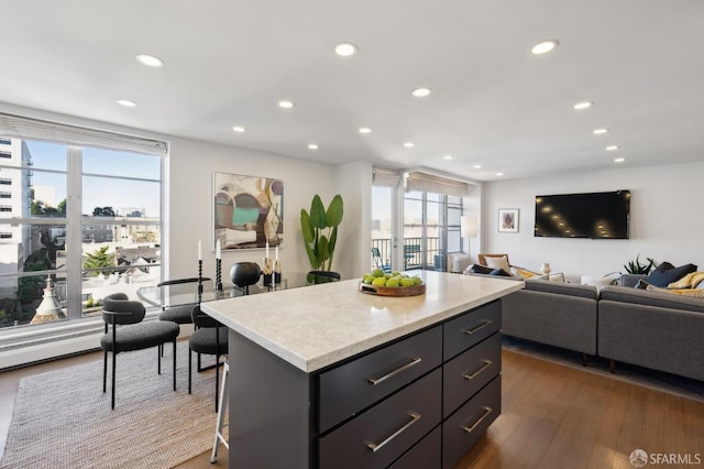 kitchen featuring a kitchen breakfast bar, a center island, and dark wood-type flooring