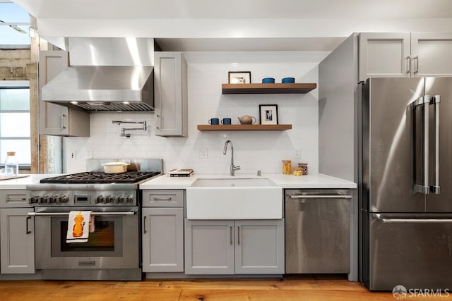 1 Rausch St Unit A, San Francisco, CA 94103 - kitchen with stainless steel appliances, wall chimney exhaust hood, gray cabinetry, light countertops, and tasteful backsplash