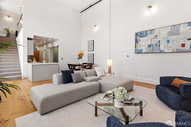 1 Rausch St Unit A, San Francisco, CA 94103 - living area with a barn door, light wood-type flooring, stairs, and a high ceiling