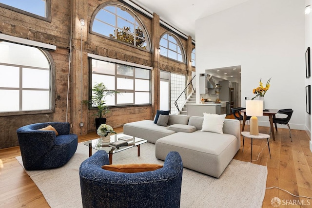 1 Rausch St Unit A, San Francisco, CA 94103 - living room featuring a towering ceiling, stairway, light wood-style flooring, and wooden walls