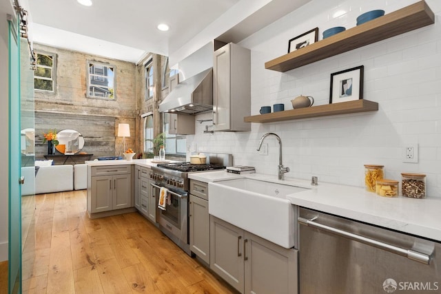 1 Rausch St Unit A, San Francisco, CA 94103 - kitchen with appliances with stainless steel finishes, gray cabinetry, light countertops, open shelves, and wall chimney exhaust hood