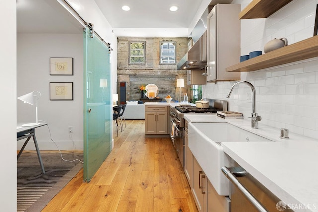 1 Rausch St Unit A, San Francisco, CA 94103 - kitchen with double oven range, wall chimney range hood, light countertops, light wood-type flooring, and tasteful backsplash