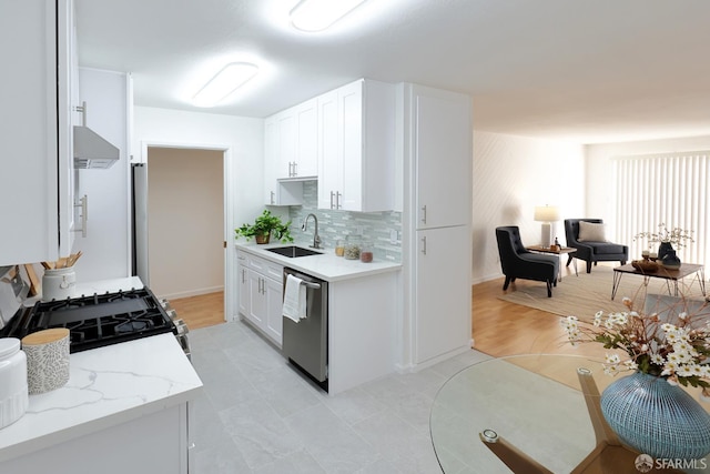 kitchen with white cabinetry, range hood, dishwasher, and sink