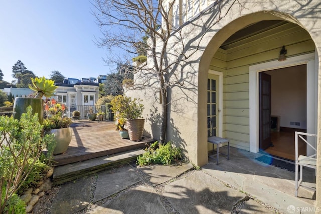 entrance to property with visible vents and a deck