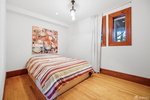 bedroom with baseboards and wood finished floors