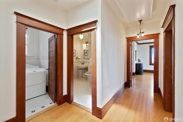 4020 20th St, San Francisco, CA 94114 - hallway featuring washer / clothes dryer, light wood-type flooring, attic access, baseboards, and crown molding