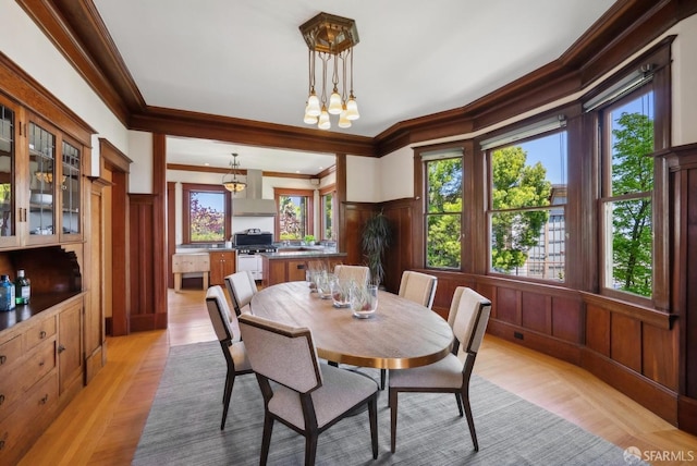 4020 20th St, San Francisco, CA 94114 - dining room with healthy amount of natural light, crown molding, a decorative wall, light wood-style flooring, and wainscoting